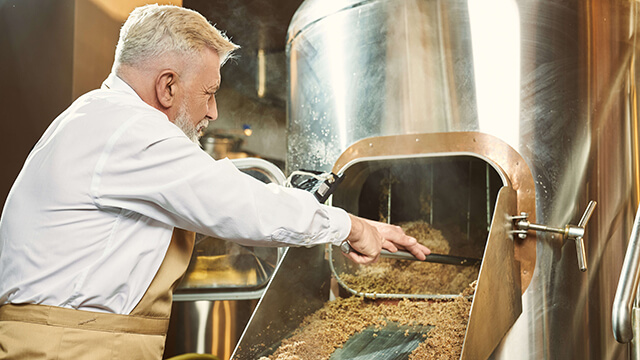 man working with spent grain