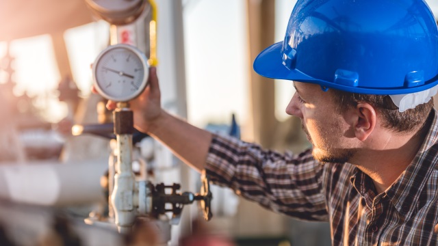man in blue helmet inspecting pressure 640x360